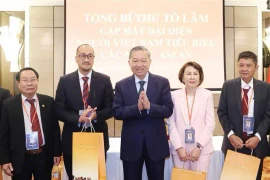 Le secrétaire général du Comité central du Parti communiste du Vietnam, To Lam (au centre), offre des cadeaux à des Vietnamiens exceptionnels vivant dans les pays de l'ASEAN. (Photo : VNA)