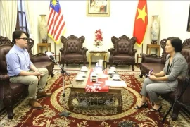 Enzo Sim Hong Jun, chercheur en histoire à l'Institut de recherche de Penang (gauche) lors d'une rencontre avec une correspondante de la VNA à Kuala Lumpur. Photo : VNA