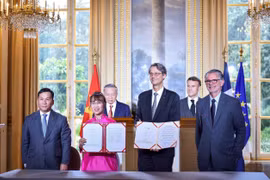La Dr Nguyen Thi Phuong Thao, présidente de Vietjet, Dinh Viet Phuong, directeur général de Vietjet (premier, gauche), Olivier Andries, Président-directeur général de Safran (2 à droite) et Gaël Méheust, président-directeur général de CFM International (droite) lors de la cérémonie signature en présence du digigeant To Lam et du président français Emmanuel Macron. Photo