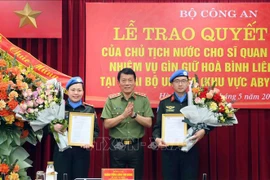 Le vice-ministre de la Sécurité publique Luong Tam Quang présente la décision du président à deux agents de la Sécurité publique d'effectuer des missions de maintien de la paix des Nations Unies. Photo: VNA