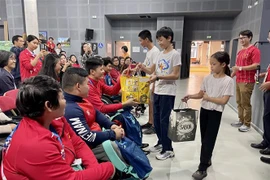 Des Vietnamiens en France offrent des cadeaux aux sportifs handicapés vietnamiens. Photo: VNA