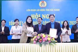 Le dirigeant de la Confédération du travail de la province de Bac Giang signe un accord de coopération sur le programme de bien-être des travailleurs avec la société par actions du commerce international HOGI Group. Photo: VNA