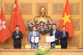 Le vice-Premier ministre Trân Luu Quang (à droite) et le chef de l'exécutif de la région administrative spéciale de Hong Kong, Lee Ka-chiu (à gauche) assistent à l'échange du protocole d'accord entre Vietnam Airlines et l'aéroport international de Hong Kong (HKIA). Photo : VNA