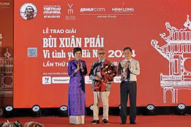 La directrice générale de l’Agence vietnamienne d’information (VNA) Vu Viêt Trang (à gauche) et le vice-président du Comité populaire de Hanoi Hà Minh Hai (à droite) remettent le Grand Prix du Prix «Bui Xuân Phai - Pour l’amour de Hanoi» à l’architecte Hoàng Dao Kinh, à Hanoi, le 8 octobre. Photo : VNA