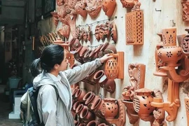 Une touriste visitant le village de potterie de Bat Tràng, à Hanoi. Photo: baoangiang.com.vn