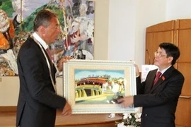 Le dirigeant de ancienne cité de Hoi An, Nguyen Duc Hai offre un cadeau au maire de Wernigerode, Peter Gaffert. Photo : VNA