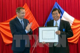 M. Jean-Noël Poirier, ambassadeur de France au Vietnam, remet l'insigne de l'Ordre national du Mérite à M. Nguyen Van Me. (Source : VNA)