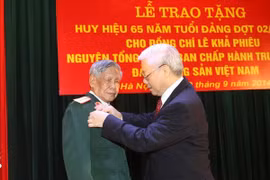 Le secrétaire général du PCV Nguyen Phu Trong a remis l'insigne des "65 ans de membre du Parti" à l'ancien secrétaire du PCV Le Kha Phieu. (Photo: Tri Dung/VNA)