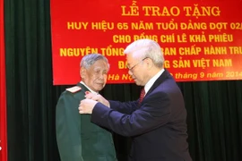 Le secrétaire général du PCV Nguyen Phu Trong a remis l'insigne des "65 ans de membre du Parti" à l'ancien secrétaire du PCV Le Kha Phieu. (Photo: Tri Dung/VNA)