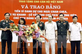 Cérémonie de remise de distinction honorifique à neuf cadres vietnamiens. (Source : VNA)