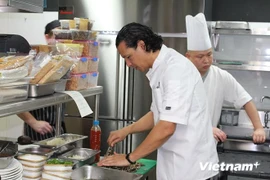 Le chef cuisinier Bobby Chinn (premier plan) prépare et propose aux invités de l’hôtel Movenpick Heritage Hotel Sentosa à Singapour certaines spécialités du Vietnam. (Source : VNA)