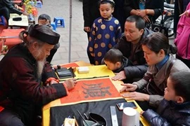 Demander une calligraphie à l'occasion du Nouvel An est un beau trait culturel de la tradition des Vietnamiens. Photo : VNA