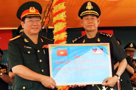 L'attaché militaire vietnamien au Cambodge, le colonel Nguyen Anh Dung (gauche), a remis 154.000 dollars à la partie cambodgienne dans la province cambodgienne de Kampong Cham. (Source : VNA)