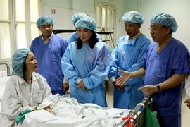 La ministre de la Santé, Nguyên Thi Kim Tiên, rend visite à l’un des patients ayant reçu l’un des organes d’un donneur en état de mort cérébrale, opérations réalisées à l’hôpital Viêt Duc (Hanoi) en juillet 2013. Photo : VNA
