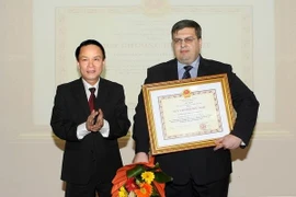 Le directeur général de la VNA, Nguyen Duc Loi et le représentant en chef de l'Agence russe TASS au Vietnam, Denhisovich Yuri Alexandrovitch (droite). (Photo: Pham Kien/VNA)