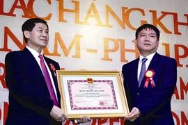 Johnathan Hanh Nguyên (gauche) reçoit l’Ordre d’amitié du président de la République, des mains du ministre du Transport et des Communications, Dinh La Thang. Photo : Hoàng Hai/VNA