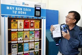 Le directeur de la compagnie des livres électroniques Tre (Ybook), Dông Phuoc Vinh, à côté d'un distributeur automatique de livres. 