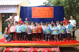 Des représentants de la Sarl Canon Vietnam offrent des cadeaux aux élèves de la province de Lao Cai. Photo: laodong.com.vn.