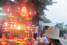 Une petite fille s'intéresse aux lanternes de couleur vive de Hôi An, province de Quang Nam (Centre). 
