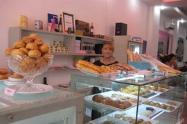 Muriel derrière ses étals de chouquettes et de pains au chocolat, comme à la maison!