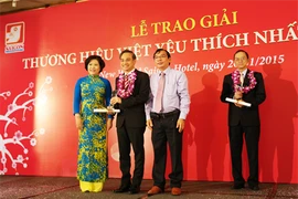 Mme Nguyên Thi Hông, à côté des représentants d'entreprises primées lors de la cérémonie de remise du prix «Marque préférée du Vietnam en 2014». 