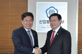 Le président de la Commission économique du CC du PCV Vuong Dinh Hue (droite) et le ministre de l'Industrie, de l'Economie et du Commerce extérieur Yoon Sang-jick (gauche). Photo : VNA