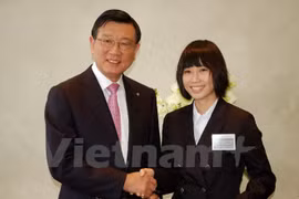 Le président du groupe sud-coréen Kumho Asiana, Park Sam Koo, remet la bourse d'études à une étudiante vietnamienne. Photo: VNA