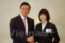 Le président du groupe sud-coréen Kumho Asiana, Park Sam Koo, remet la bourse d'études à une étudiante vietnamienne. Photo: VNA