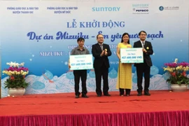 Le président de la compagnie Suntory PepsiCo Vietnam remet l'aide financière au représent du Service de l'éducation et de la formation dans le district de Thanh Oai. 