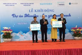 Le président de la compagnie Suntory PepsiCo Vietnam remet l'aide financière au représent du Service de l'éducation et de la formation dans le district de Thanh Oai. 