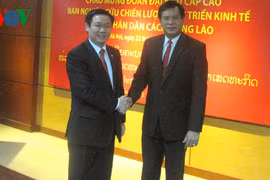 Le chef de la Commission centrale de l'Economie du PCV, Vuong Dinh Hue (gauche), reçoit l'ancien Premier ministre du Laos Bouason Bouphavan. Photo: VOV