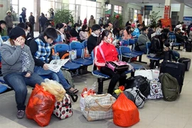 Des passagers attendent leur tour afin d’acheter des billets de bus. Photo : Thê Duyêt/VNA