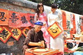 De nombreux Vietnamiens -qu'importe leur classe sociale- demandent, à l’occasion du Têt, une calligraphie. Photo : VNA