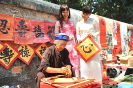 De nombreux Vietnamiens -qu'importe leur classe sociale- demandent, à l’occasion du Têt, une calligraphie. Photo : VNA