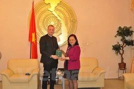 Le Secrétaire d'Etat du ministère de la Justice du Land de Brandebourg, Ronald Pienkny remet des livres à l'ambassadeur du Vietnam en Allemagne, Mme Nguyen Thi Hoang Anh.