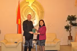 Le Secrétaire d'Etat du ministère de la Justice du Land de Brandebourg, Ronald Pienkny remet des livres à l'ambassadeur du Vietnam en Allemagne, Mme Nguyen Thi Hoang Anh.