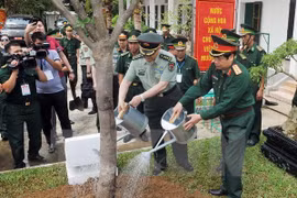 Le général Phung Quang Thanh, ministre vietnamien de la Défense et le ministre chinois de la Défense Chang Wanquan plantent un arbre au district Muong Khuong. Photo : VNA