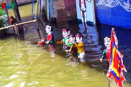 A Hông Phong, le rideau rouge s'ouvre et des marionnettistes-paysans entrent en scène