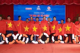 Dons spéciaux en drapeaux nationaux aux habitants et soldats à Ninh Thuân