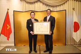 Hoang Binh Quan (gauche), ancien président de la Commission centrale des relations extérieures du Parti communiste du Vietnam (PCV), a reçu l'Ordre du Soleil levant, Grand-Croix de la première classe du Japon lors d'une cérémonie tenue le 15 décembre à Hanoï. Photo: VNA