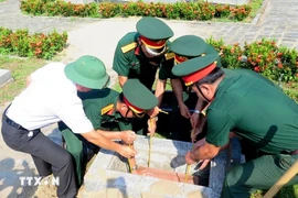 Lors de la céréminie d'inhumation des restes de 15 soldats volontaires et experts vietnamiens tombés au Laos et au Cambodge. Photo: VNA