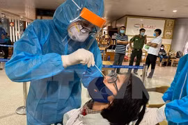 Tests aléatoires du COVID-19 avec des passagers arrivant à l'aéroport de Tan Son Nhat