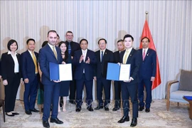 Le Premier ministre Pham Minh Chinh (centre) assiste à la remise du protocole d'accord sur la recherche d'investissement dans le projet de complexe sportif et de centre commercial à Dong Anh entre T&T du Vietnam et JTA International Holding. Photo : VNA