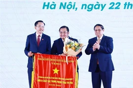 Le Premier ministre Pham Minh Chinh offre le drapeau d'émulation au Groupe chimique du Vietnam (Vinachem). Photo : VNA