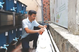 Nguyên Tuân Anh vérifie la décomposition des bouteilles de solution pour créer un engrais organique microbien. Photo : VNA/CVN
