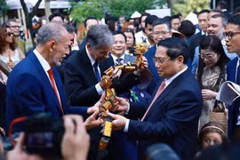 Le Premier ministre Pham Minh Chinh offre des marionnettes sur l'eau à des délégués. Photo : VNA