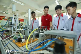 Présentation de modèles d'automatisation aux étudiants de la classe d'électronique industrielle K13 du Collège professionnel de haute technologie de Hanoi. Photo : Hoang Hieu/VNA