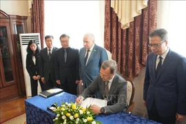 Le vice-président du Conseil de la Fédération de Russie, Alekseï Yatskin, écrit dans le registre de condoléances. Photo: VNA