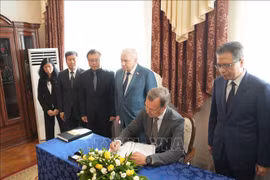 Le vice-président du Conseil de la Fédération de Russie, Alekseï Yatskin, écrit dans le registre de condoléances. Photo: VNA