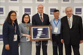 La directrice générale adjointe de la VNA Doan Thi Tuyet Nhung (2e, gauche) offre un souvenir au directeur général de l'agence de presse TASS, Andrey Kondrashov. Photo : VNA